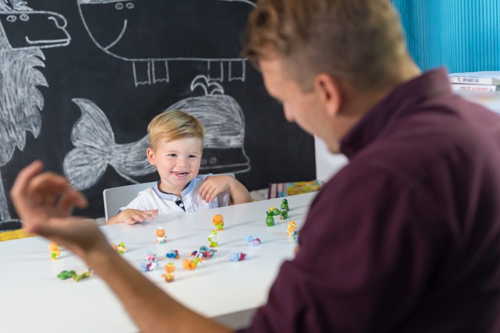 Speech therapist helping a young boy with a phonological disorder in a therapy session