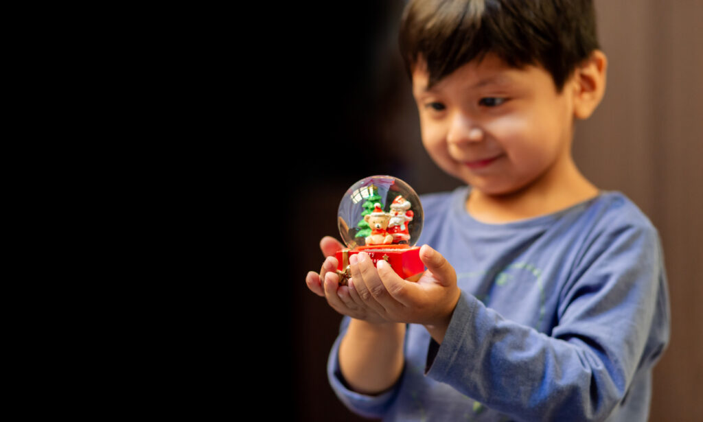 Young Boy Looking at a Snow Globe