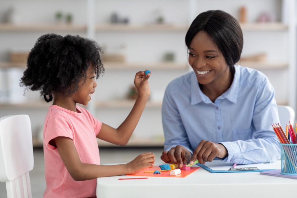Speech therapist working with a young child in a play-based speech therapy session to support communication skills