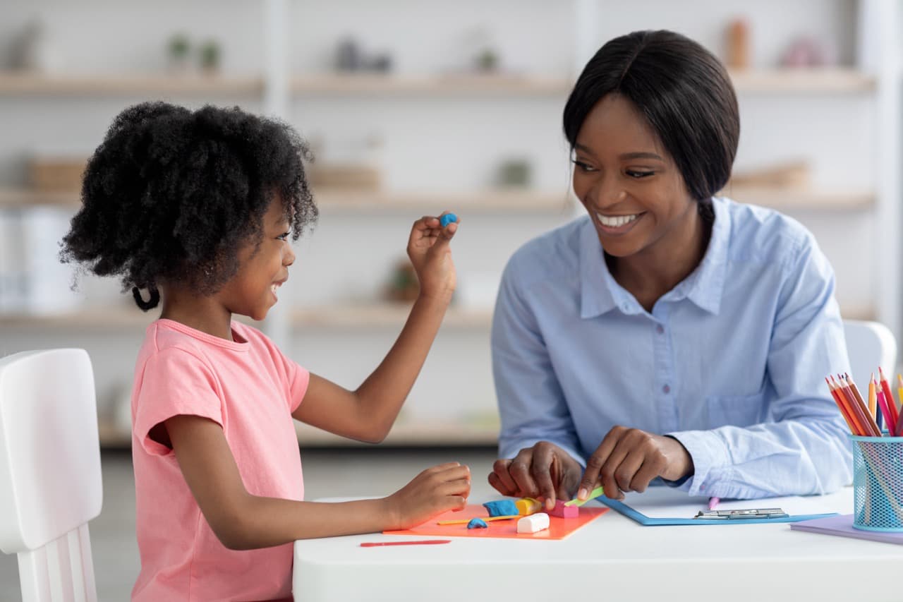 Speech therapist working with a toddler during an early intervention session at home.
